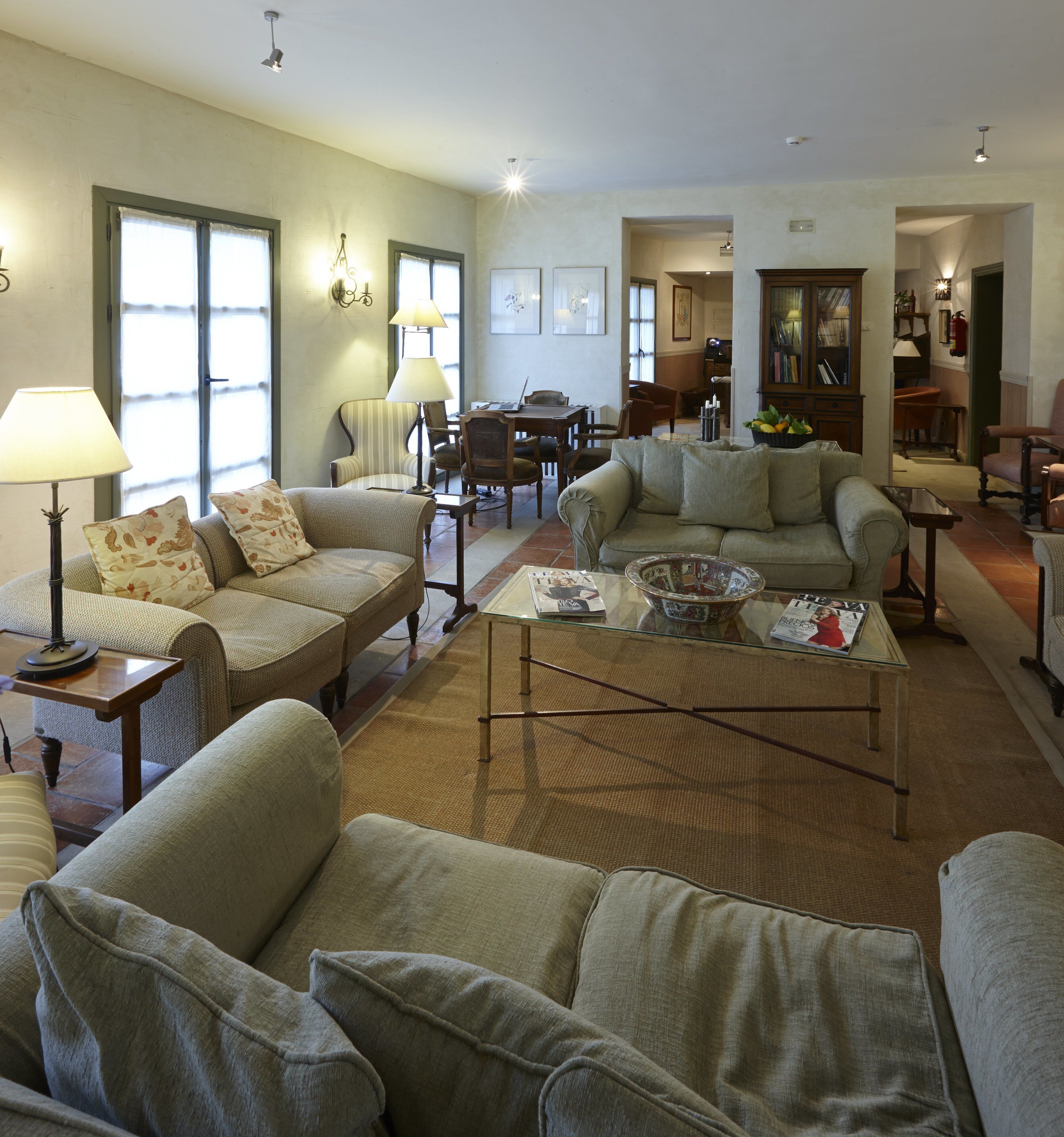 A spacious living room with multiple seating areas, a coffee table, and a dining table.