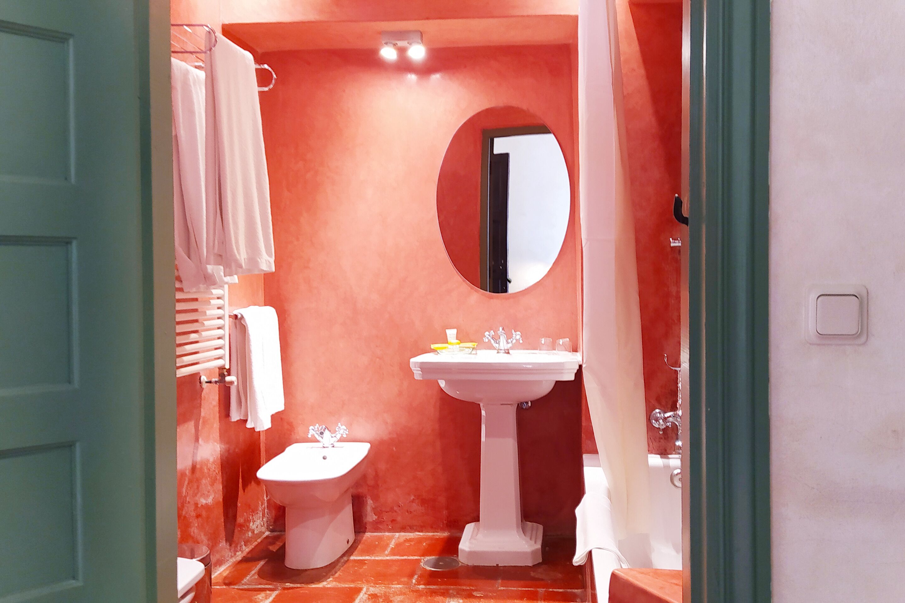 A bathroom with a bidet, a sink, and a mirror.