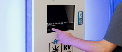 A check-in point with a digital screen, a QR code, and the RVHotels logo.