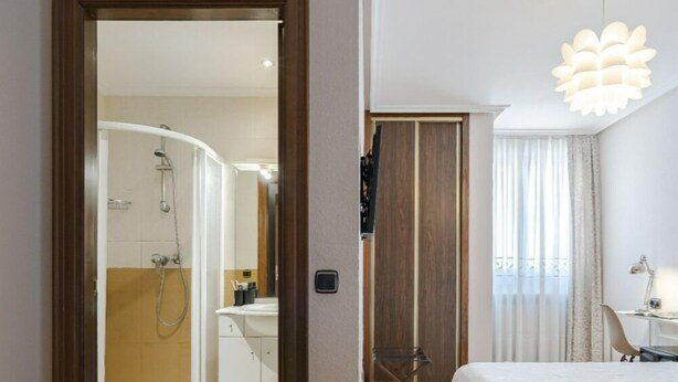 A hotel room with a shower, a bed, a desk, and a chair. - Hotel Salamanca Rio (Salamanca)