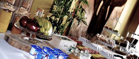 A buffet with various food items including fruits, dairy products, and pastries.