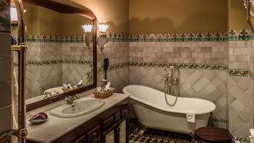 Un baño con una bañera independiente, un lavamanos y un inodoro.