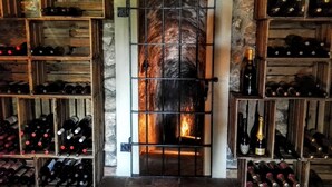 A wine cellar with wooden shelves and a stone wall. - Hotel Villa Retiro (Xerta)
