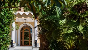 A building with a large arched entrance, a white facade, and a decorative ceiling. - Hotel Villa Retiro (Xerta)