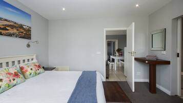 Hotelkamer met een groot bed, een bureau, een stoel en uitzicht op het landschap.