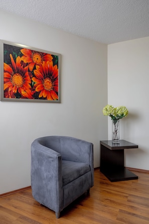 Habitación superior, 1 cama King size | Área de sala de estar | Televisión de pantalla plana 