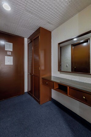 A room with a wooden wardrobe, a desk with drawers, a mirror, and a ceiling with recessed lighting. - Hotel Valle de Mexico Toreo (Naucalpan)