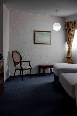 A hotel room with a single bed, a chair, a small table, and a wall-mounted picture. - Hotel Valle de Mexico Toreo (Naucalpan)