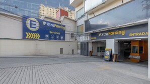 An empty parking lot with a building featuring signage for 'XtraParking' services. - Hotel Valle de Mexico Toreo (Naucalpan)