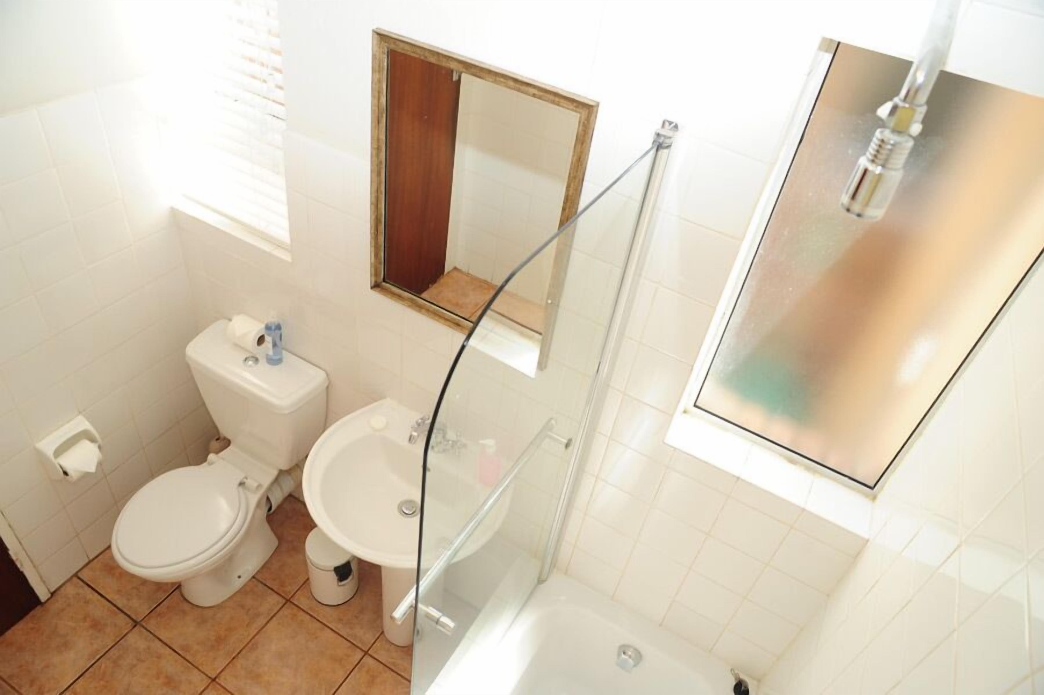A bathroom with a toilet, sink, and shower.