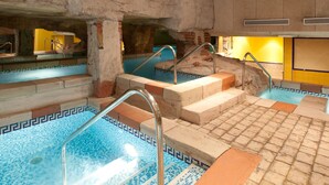 An indoor swimming pool with tiled flooring and steps leading into the water. - Senator Cadiz Hotel (Cádiz)