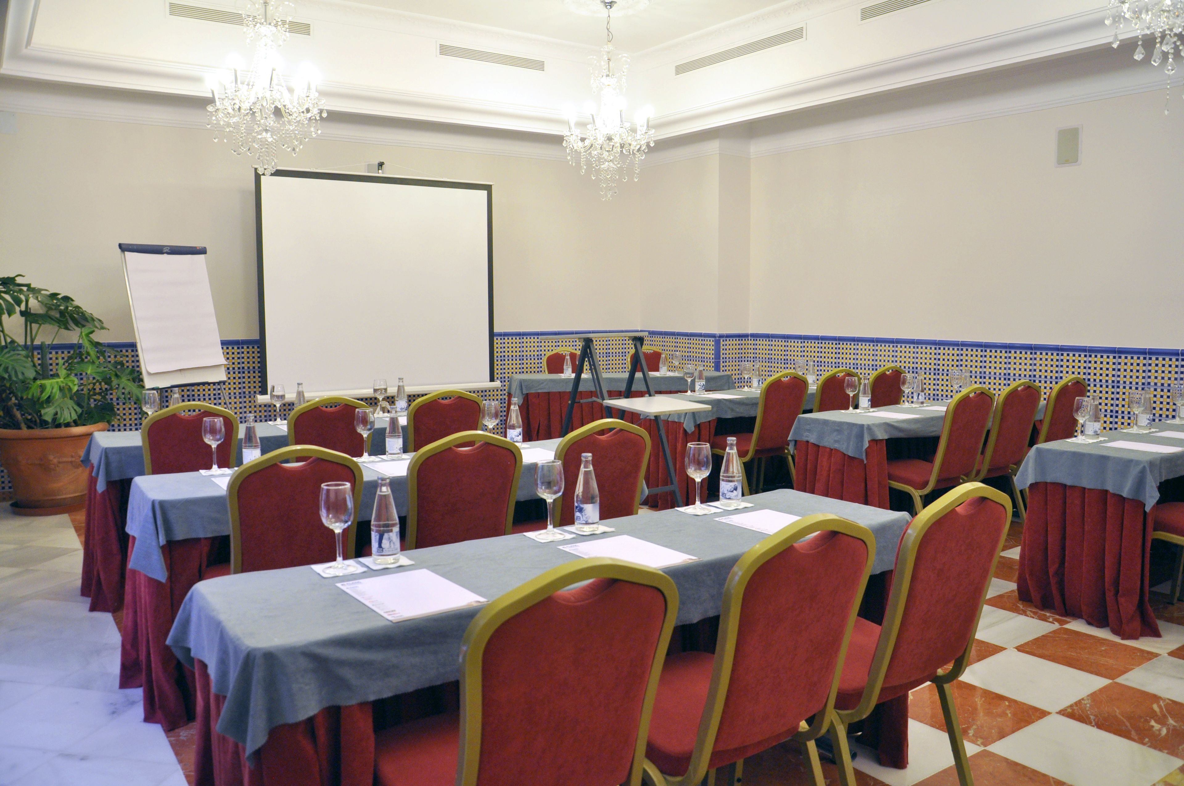 A conference room with tables set for meetings, equipped with chairs, water bottles, and documents.