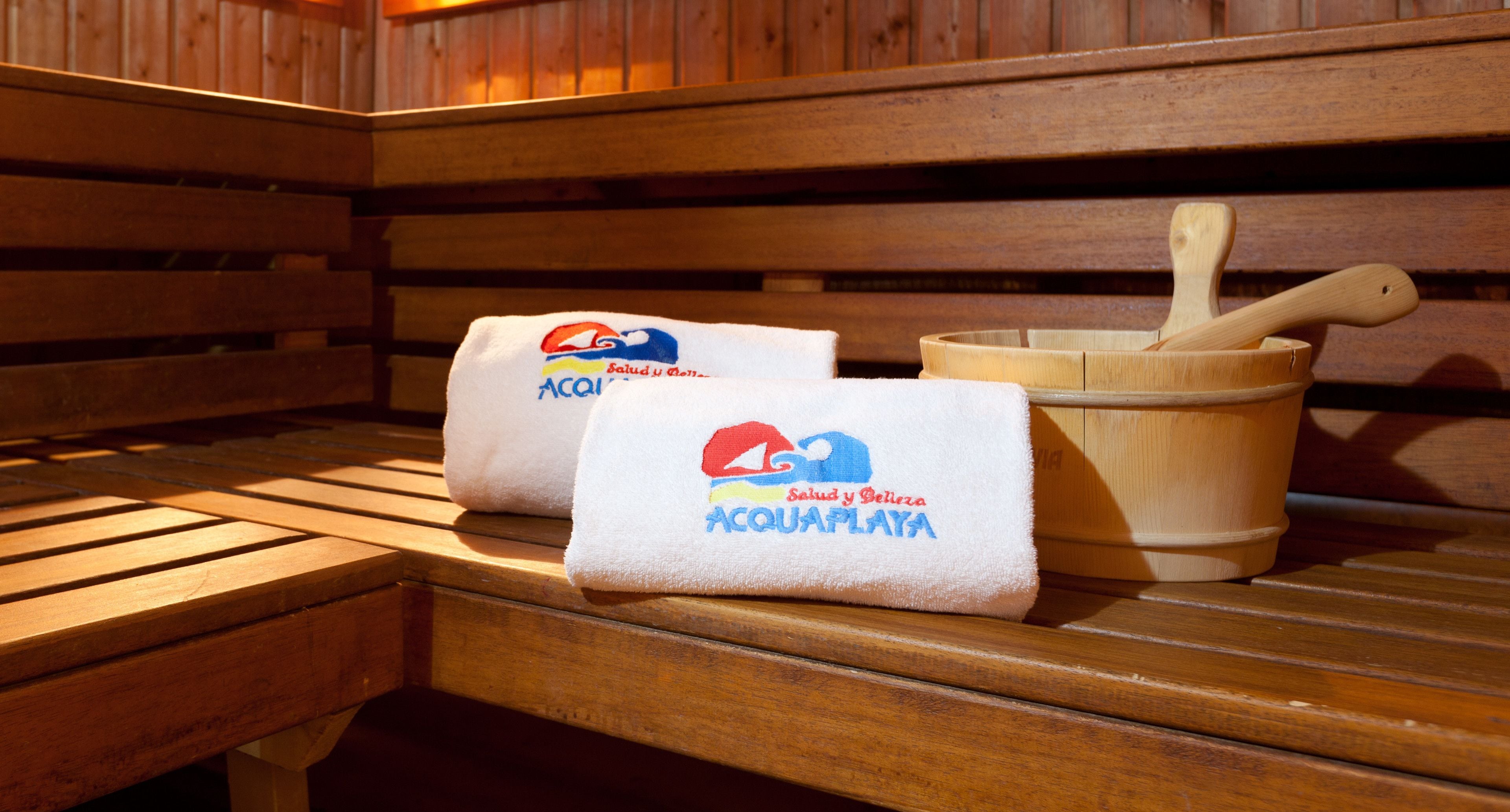 A wooden bench with two towels and a wooden bucket with a wooden spoon on it.