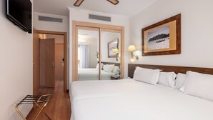 A hotel room with a large bed, a wooden headboard, a flat-screen TV mounted on the wall, and a framed picture of a beach scene. - Senator Cadiz Hotel (Cádiz)
