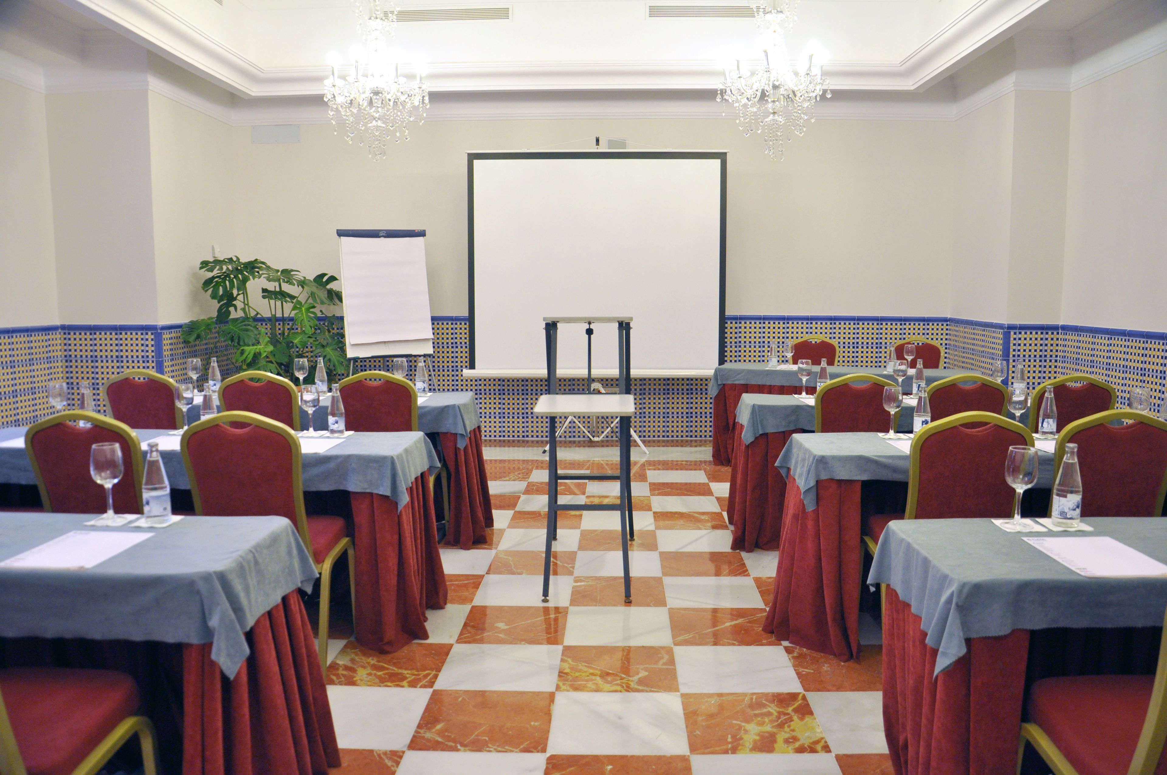 A conference room with tables, chairs, and a projector screen.