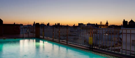 Una piscina al aire libre de temporada, tumbonas