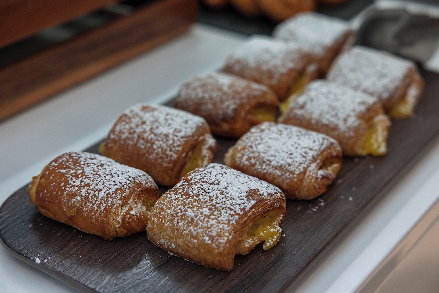 Una bandeja de pasteles espolvoreados con azúcar glas.