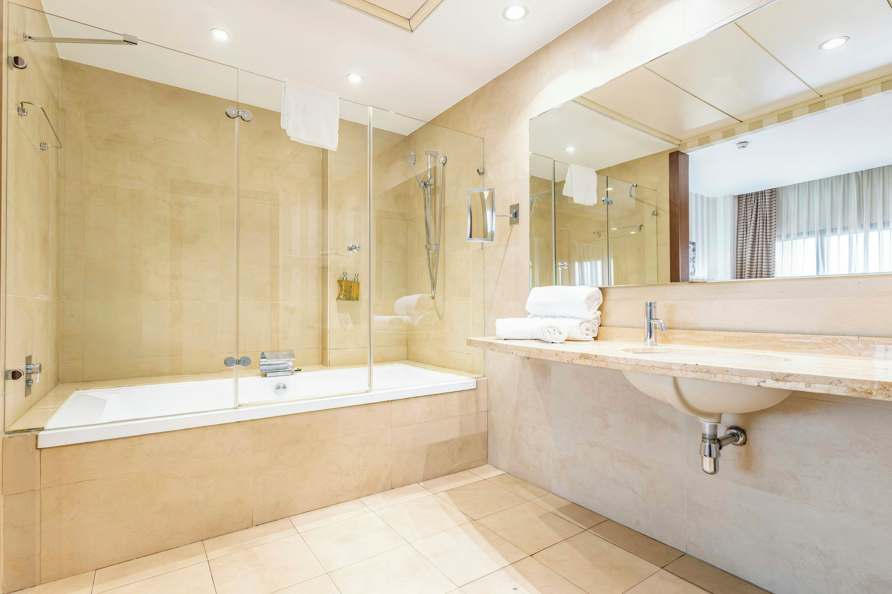 A modern bathroom with a glass-enclosed shower, a freestanding bathtub, and a vanity with a sink.