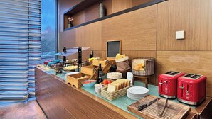 A buffet setup with various food items, a chalkboard menu, and two red toasters. - Sercotel Las Artes Pinto (Pinto)