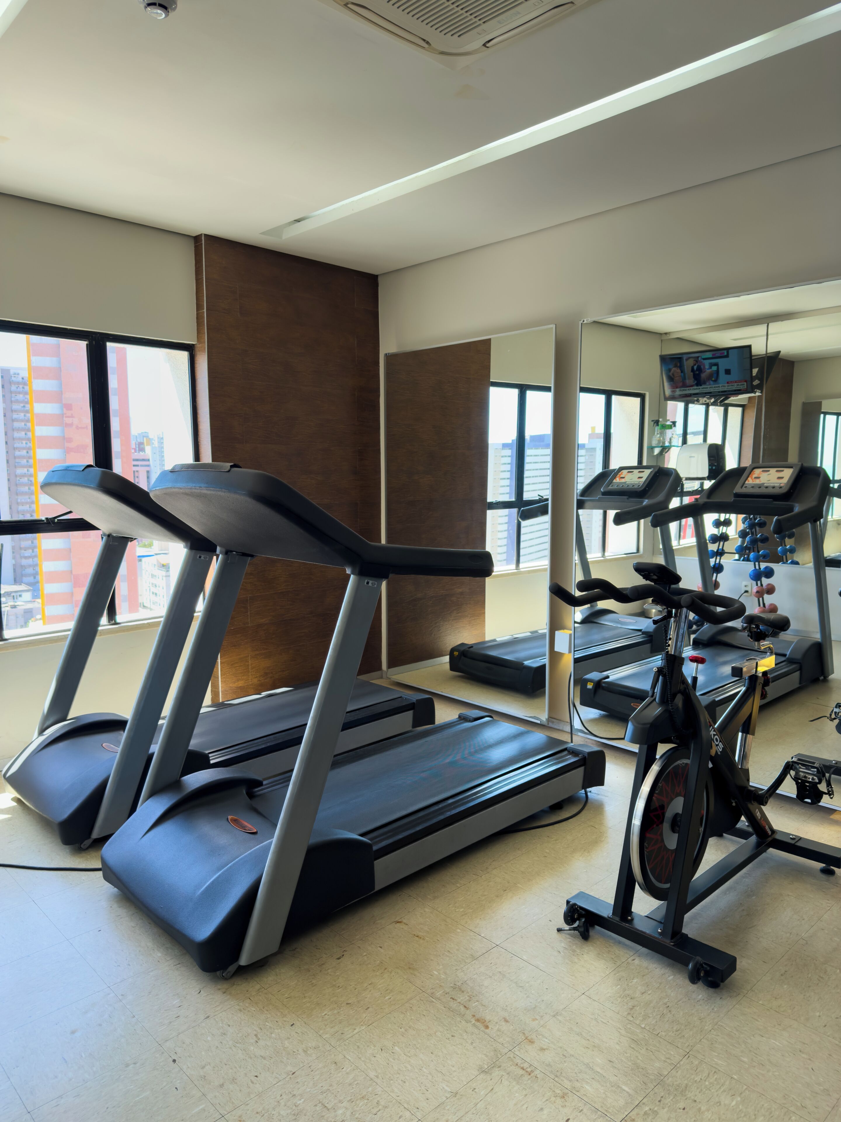 Un gimnasio con cintas de correr, elípticas y bicicletas estáticas.