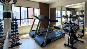 A gym with treadmills, an elliptical, and a rack of dumbbells. - Hotel Praia Centro (Fortaleza)