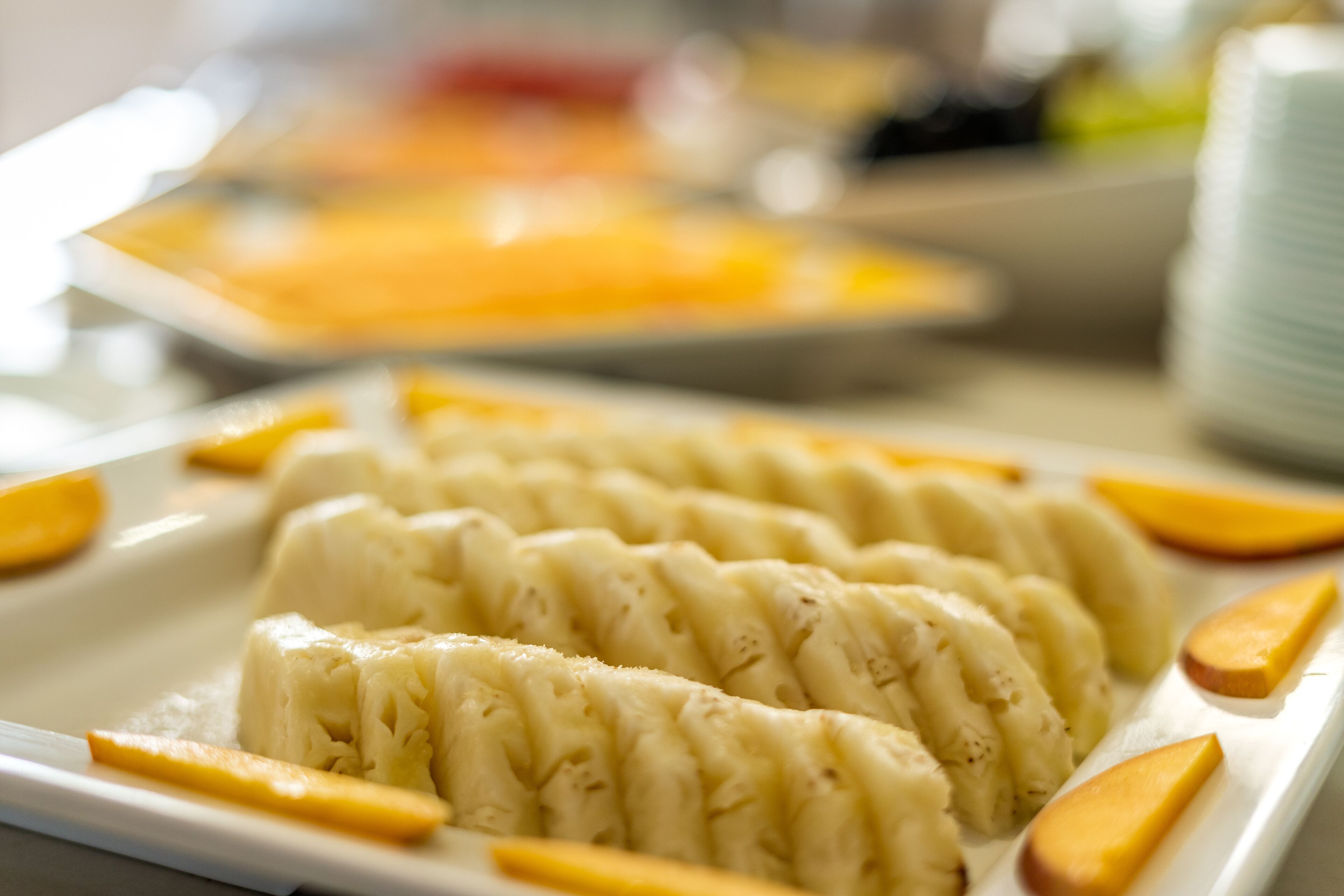 Una bandeja de postres con un plato cremoso en capas y rodajas de fruta.