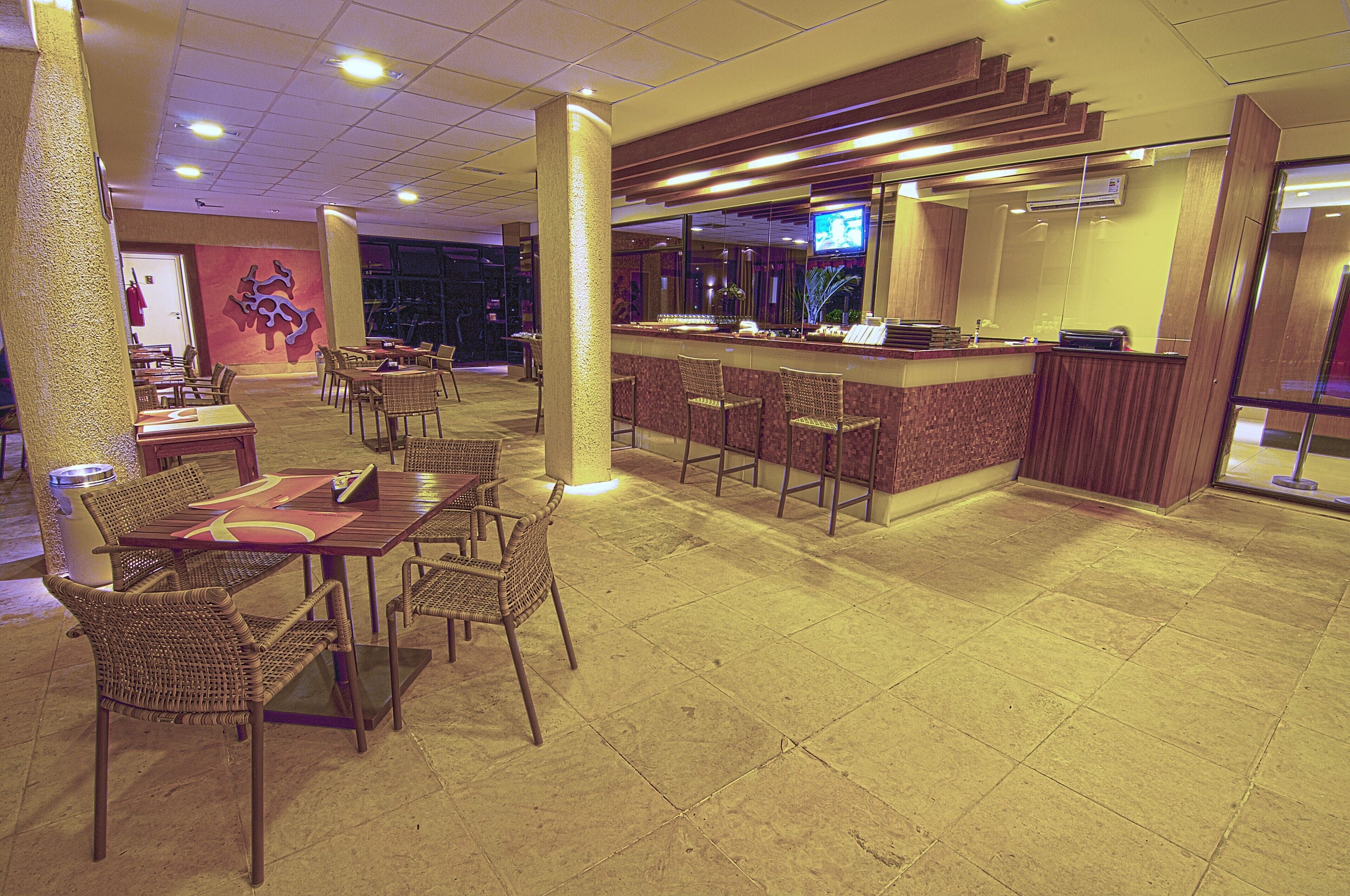Un restaurant doté d’un bar, de tables et de chaises.