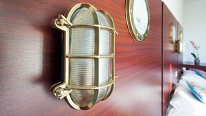 A wooden wall with a decorative light fixture and a mirror.