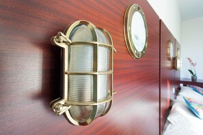 A wooden wall with a decorative light fixture and a mirror.
