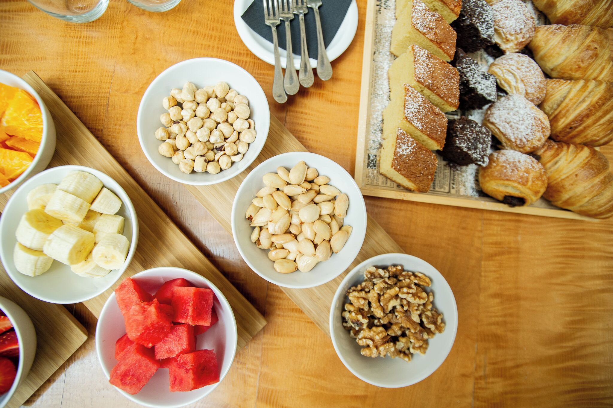A table with various food items including fruits, nuts, and pastries.