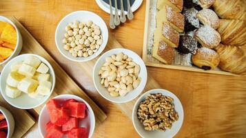 Uma mesa com diversos alimentos, incluindo frutas, nozes e doces.