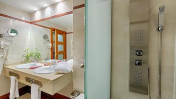 A modern bathroom with a dual sink vanity, a glass shower enclosure, and a visible towel rack.