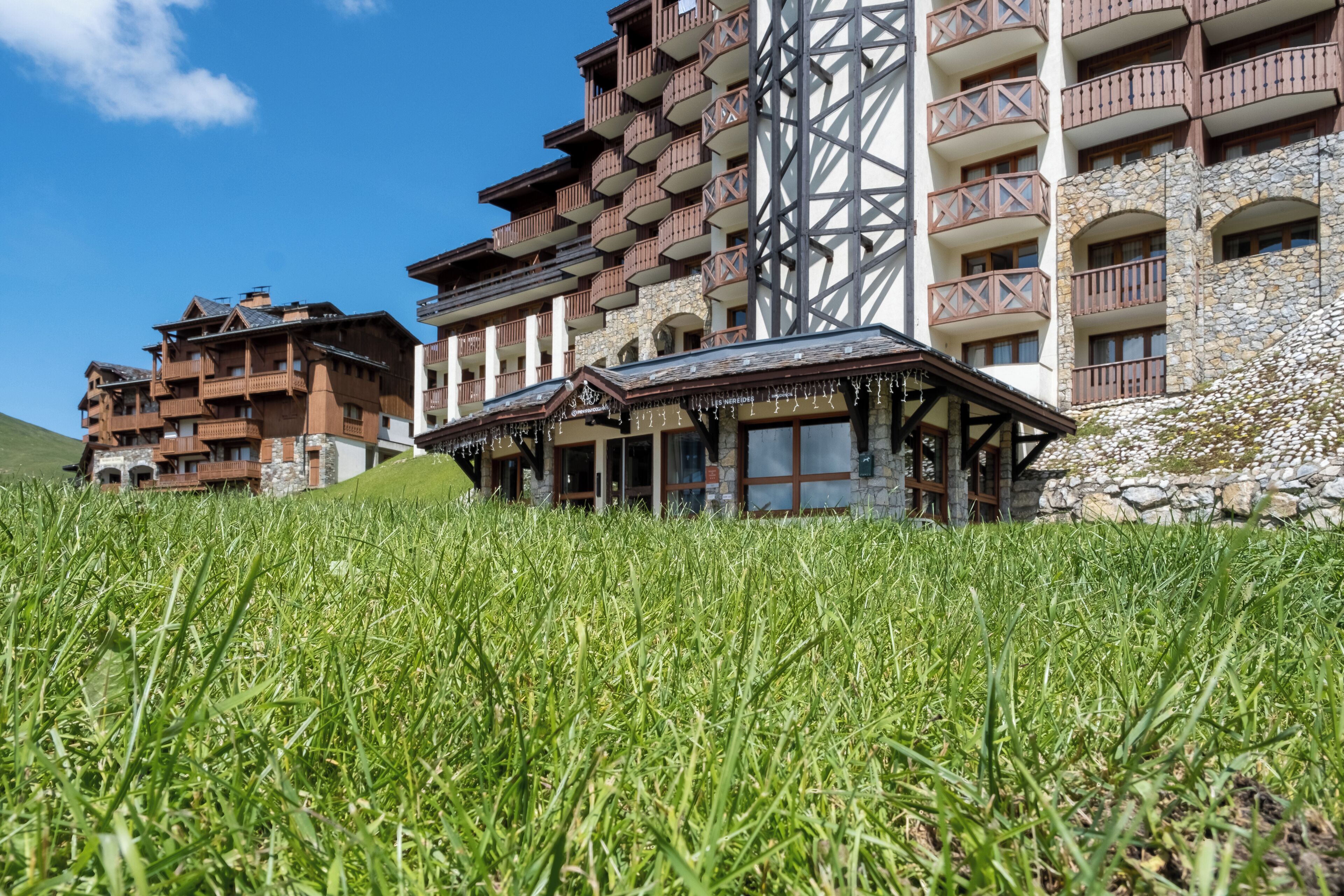 A hotel with multiple floors, balconies, and a stone facade.