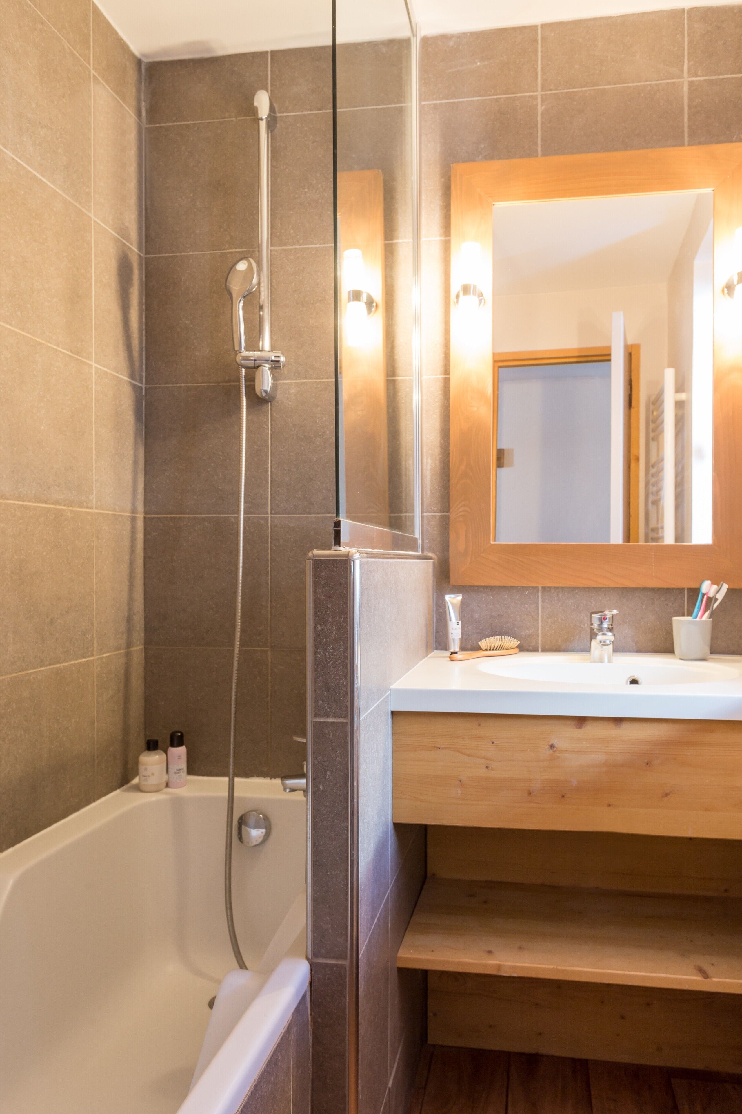 A modern bathroom with a bathtub, a shower, a vanity with a mirror, and a sink.