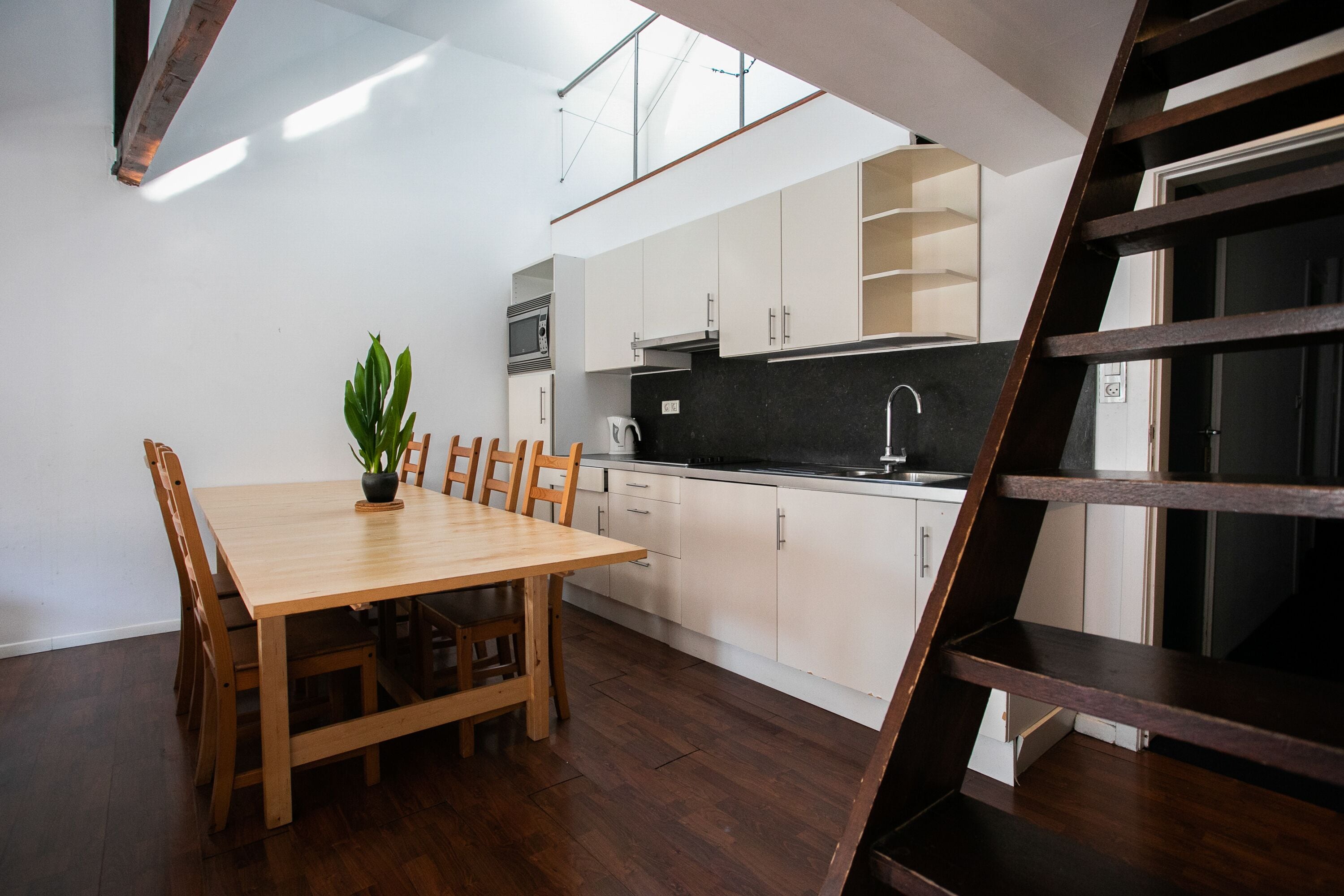 Una cocina moderna con armarios de madera, una mesa de comedor y sillas.