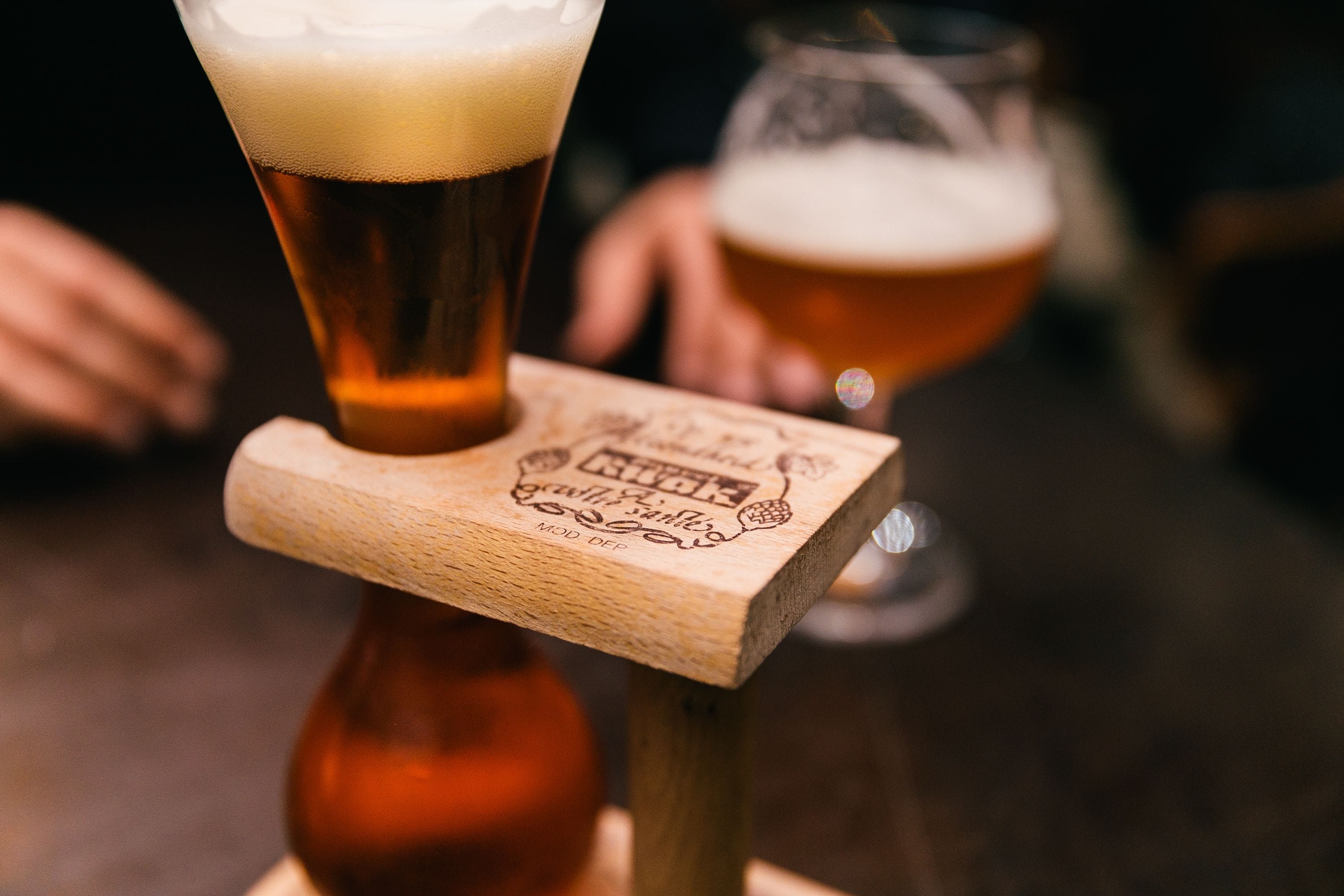 Una barra de madera con vasos de cerveza.