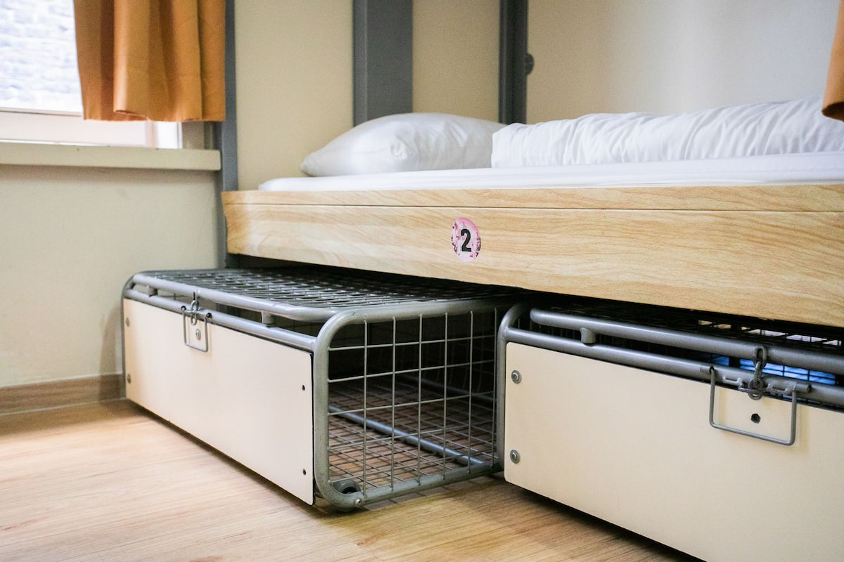 Een stapelbed met een onderste bed die een metalen omheining heeft.