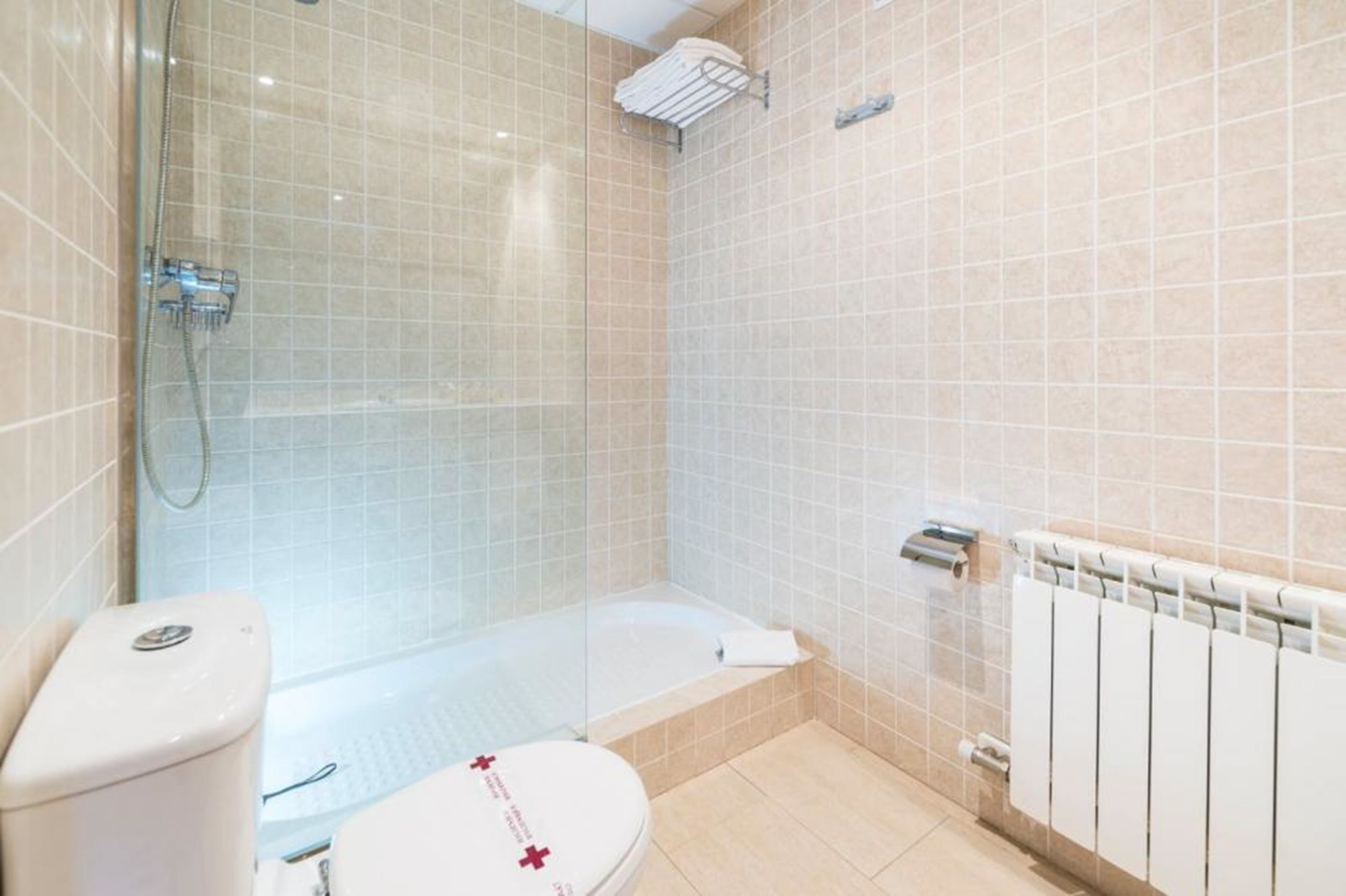 A bathroom with a toilet, a shower, and a bathtub.
