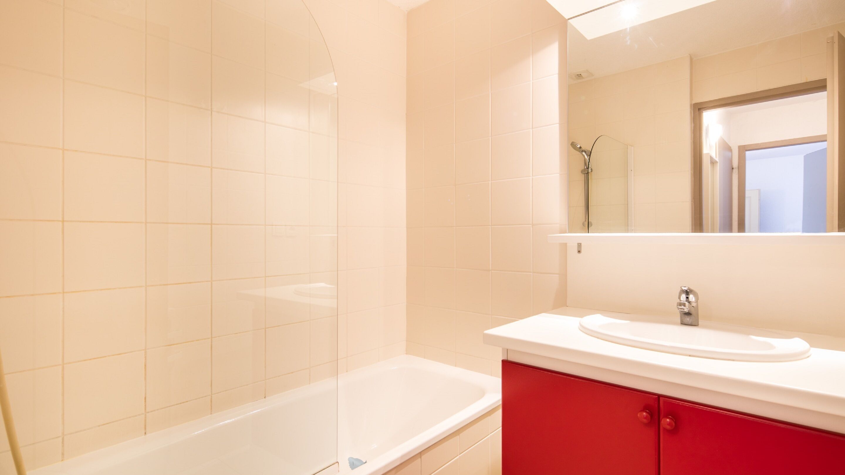 A modern bathroom with a bathtub, a sink, and a mirror.