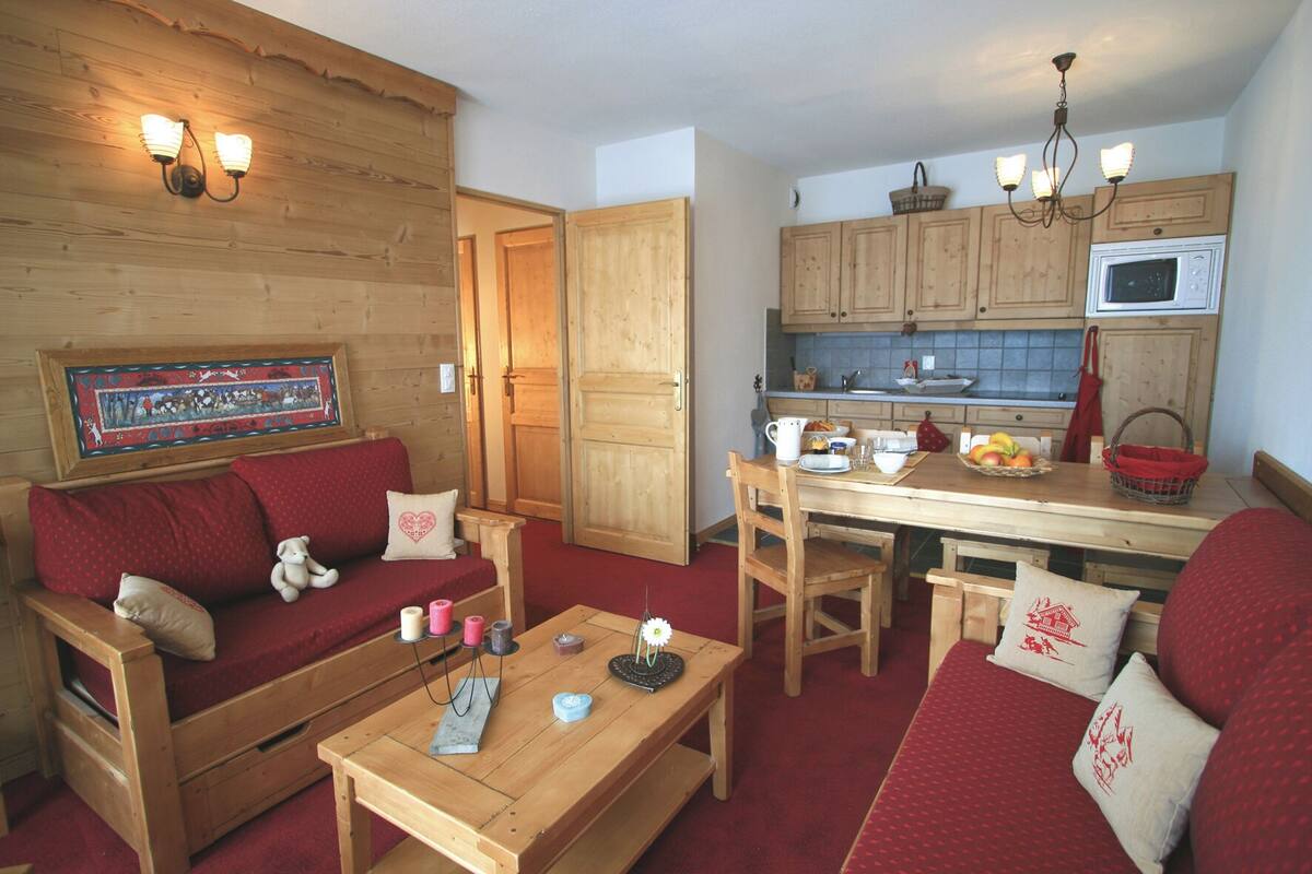 Ein gemütliches Zimmer mit einer Holzdirektiva, einem Couchtisch aus Holz und einer Küchenzeile mit Holzschränken und einer Mikrowelle.