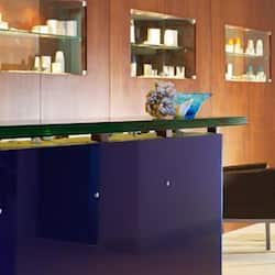 Guests can check in at the reception desk, where they may browse items for sale or services offered in the display cabinets.