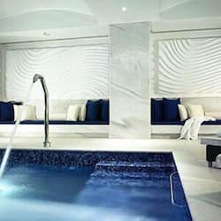 Relax in a tranquil space with a large pool, clean lines, and comfortable seating areas.