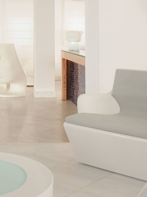 Relax in a comfortable lounge area with a sofa and coffee table, surrounded by a unique sculpture installation.