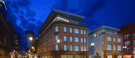 A multi-story building with a modern architectural design, featuring large windows and a flat roof.
