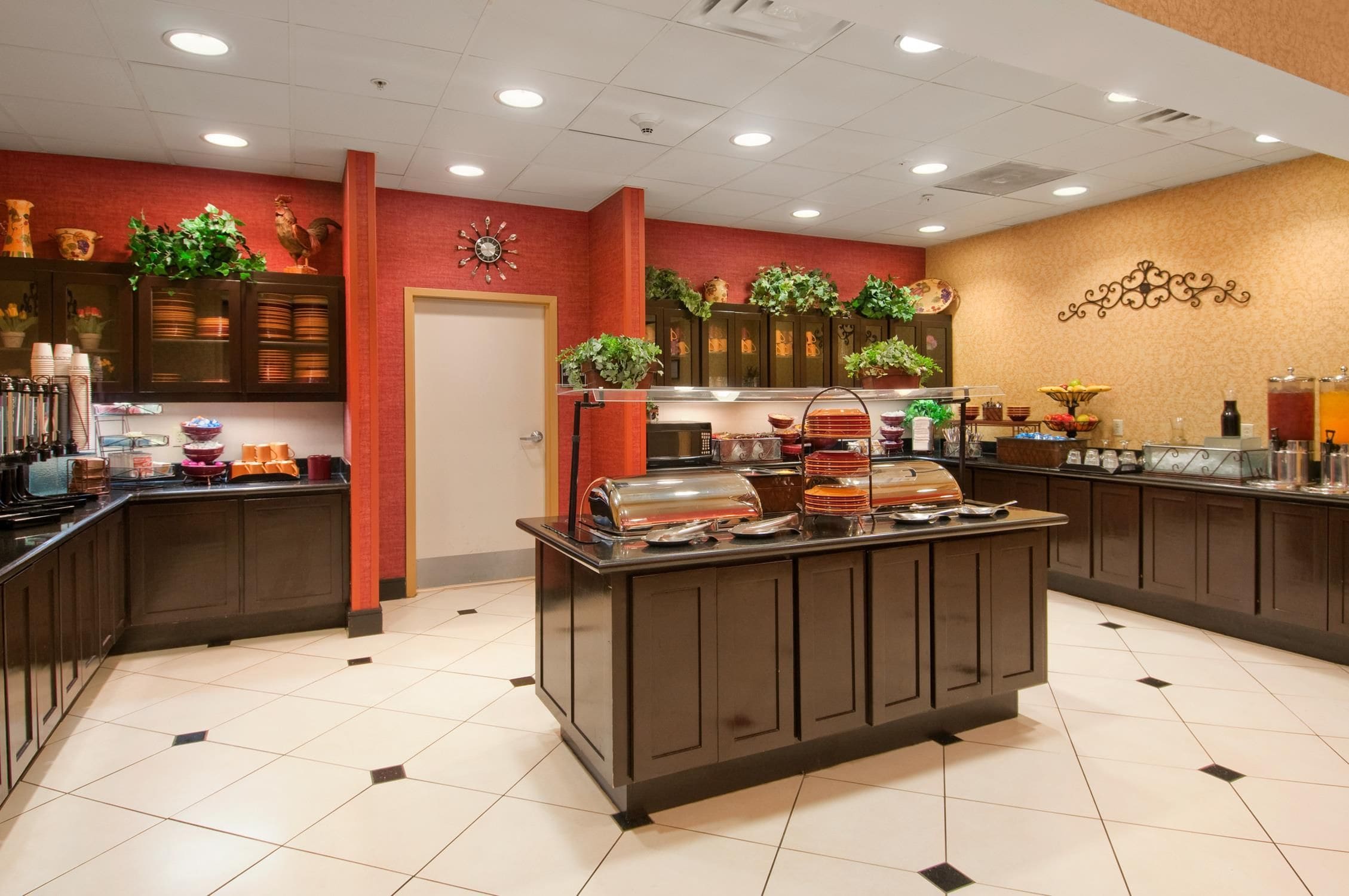 A buffet area with a variety of food items and a clock on the wall.