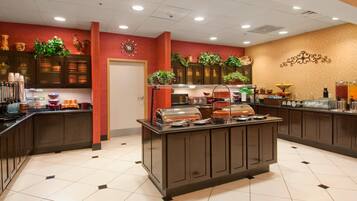 A buffet area with a variety of food items and a clock on the wall.