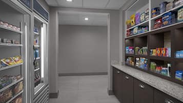 Una tienda de comestibles con estantes llenos de bocadillos y bebidas.