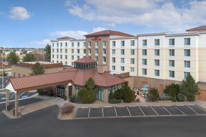 A hotel with a central courtyard, multiple floors, and a parking lot.