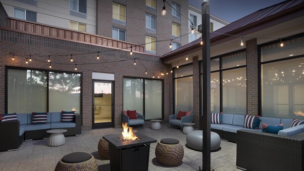 An outdoor patio area with seating, a fire feature, and string lights. - Hilton Garden Inn Denver/Highlands Ranch (Littleton)