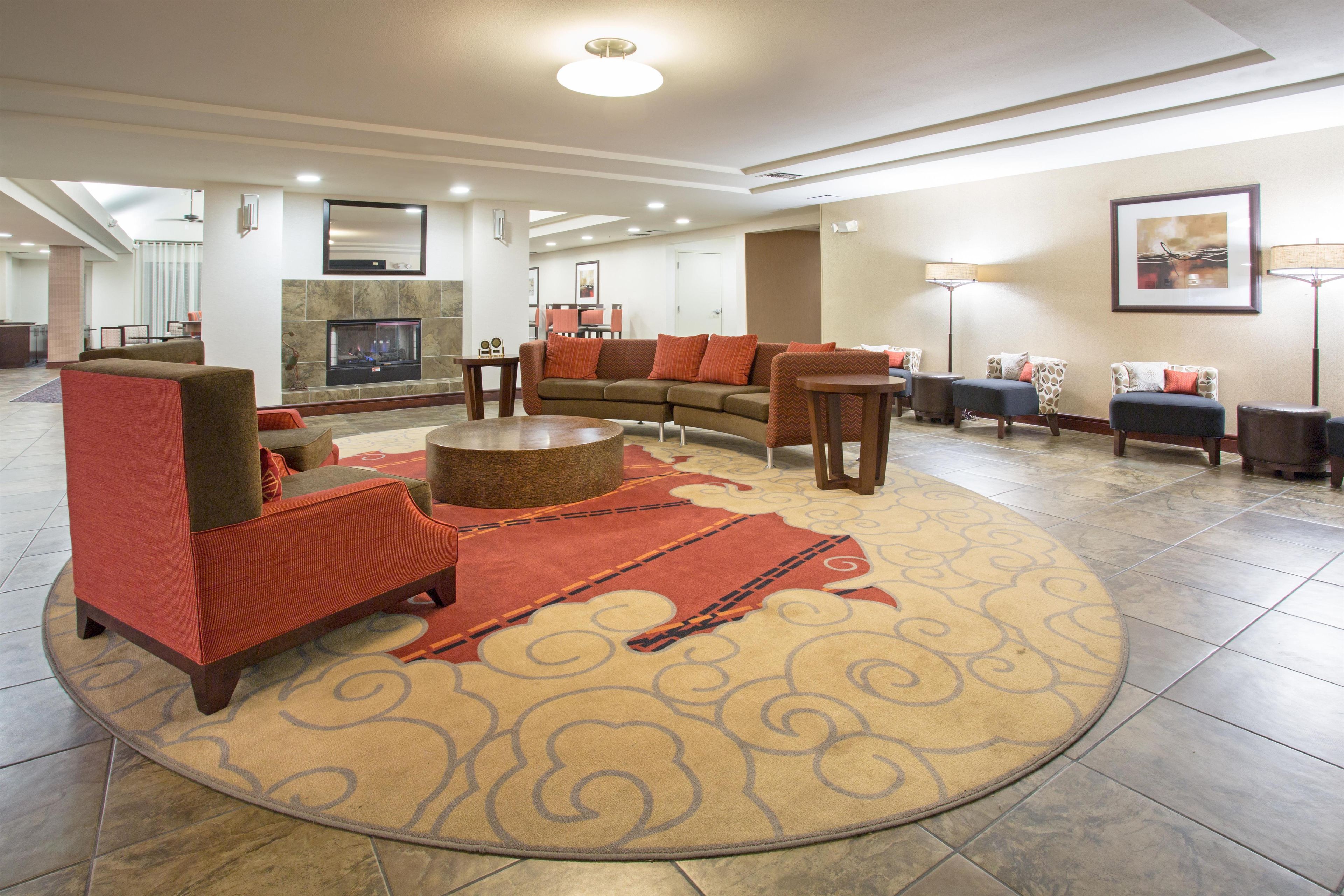 A spacious living area with a fireplace, comfortable seating, and a large rug.